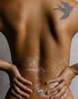 Organic body wash applied to bare back highlighting hydrated skin and natural glow during cleansing ritual.