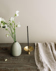 flower vase, brass ash catcher with an incense holder, linen cloth on the wooden table