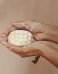 Hands holding a bar of soap with a foam