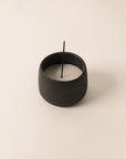 raw black ceramic cup filled with sand, designed for holding Japanese incense sticks for burning