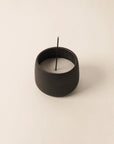 raw black ceramic cup filled with sand, designed for holding Japanese incense sticks for burning