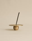 Incense stick placed in a polished brass orb incense holder, offering a modern and elegant burning experience