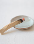 Palo Santo wood stick burning on a ceramic plate for spiritual cleansing and energy purification