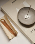 burning palo santo incense stick on the ceramic bowl and several incense sticks on the side