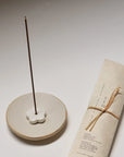 burning natural cedar incense on ceramic incense holder and with hand-wrapped packaging on the side