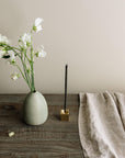 flowers with a vase, incense stick with incense holder, linen cloth on the wooden table
