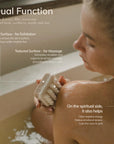 a woman scrubbing and massaging with exfoliating bar soap in the bath