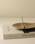 ellipse brass incense holder with floral Japanese incense holder on the plate and book