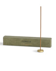 palo santo incense stick with a brass holder and the package behind