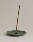 green ceramic incense holder plate with cinnamon incense stick