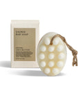 Hinoki Shea butter sacred bar soap with packaging behind