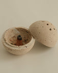 incense cone placed on a spherical travertine burner, creating a serene and elegant atmosphere