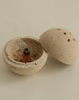incense cone placed on a spherical travertine burner, creating a serene and elegant atmosphere