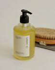 Bottle of Le Jardin body wash with a brush and soap dish