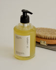 Bottle of Le Jardin body wash with a brush and soap dish