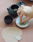Using a tea strainer to pour the tea on the side while pinching the dried tea leaves
