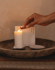 hand lighting palo santo incense cone over candle for cleansing ritual