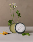 ME TIME self-massage balm with lid open and some flowers behind