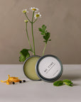 ME TIME self-massage balm with lid open and some flowers behind