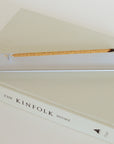 Minimal aluminum incense holder burning stick incense on book in modern home setting
