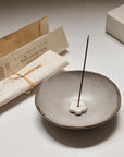 burning palo santo incense stick on ceramic holder with packages on the side