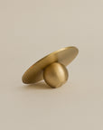 rear view of an orb shaped brass incense holder, highlighting its smooth polished finish and spherical design