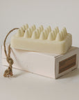 rectangular bar soap made of palo santo and shea butter placed on the top of the packaging
