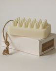 rectangular bar soap made of palo santo and shea butter placed on the top of the packaging