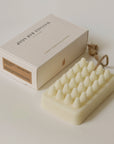 Rectangular soap bar with textured surface with rope and packaging on the side