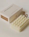 Rectangular soap bar with textured surface with rope and packaging on the side
