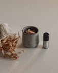 Ceramic smudging cup with bath flakes and palo santo essential oil to create a soothing and aromatic experience
