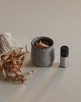 Ceramic smudging cup with bath flakes and palo santo essential oil to create a soothing and aromatic experience