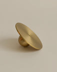 Side view of a brass incense holder shaped like an orb, showcasing its smooth, spherical design and polished finish