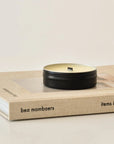 travel size wellness candle placed on the book