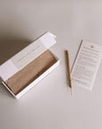 Open box of white sage incense with labeled scent notes, a single incense stick, and a Burning Rituals direction card