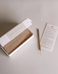 Open box of white sage incense with labeled scent notes, a single incense stick, and a Burning Rituals direction card