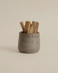 wood sticks placed on a sand ceramic smudging incense cup, ready for burning to create a calming aroma