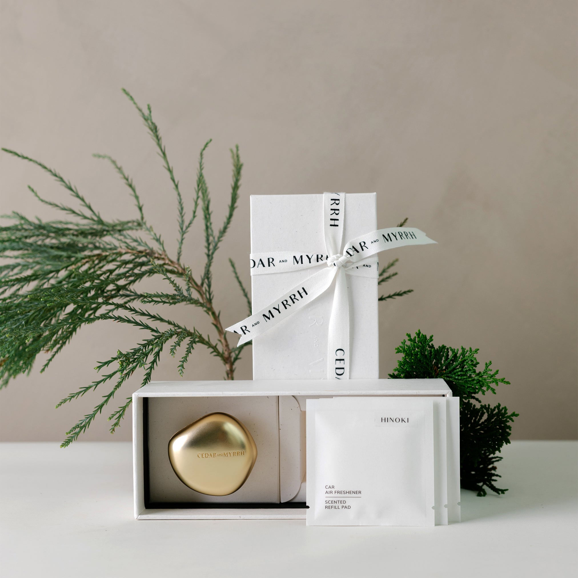 Hinoki car air freshener gift set with gold zinc alloy diffuser and three scented refill pads in a white box