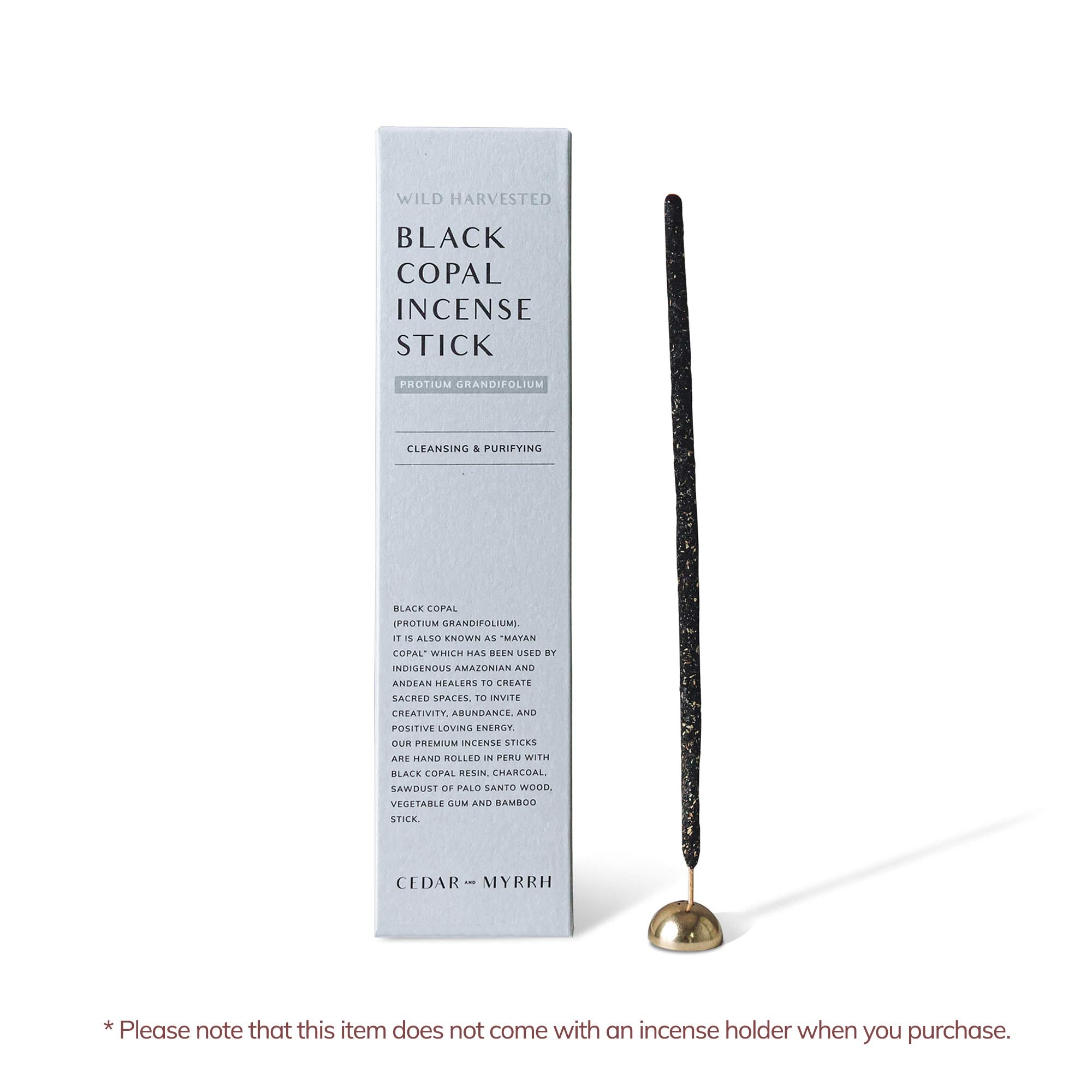 Black copal hand rolled incense stick with incense holder and package on the side.