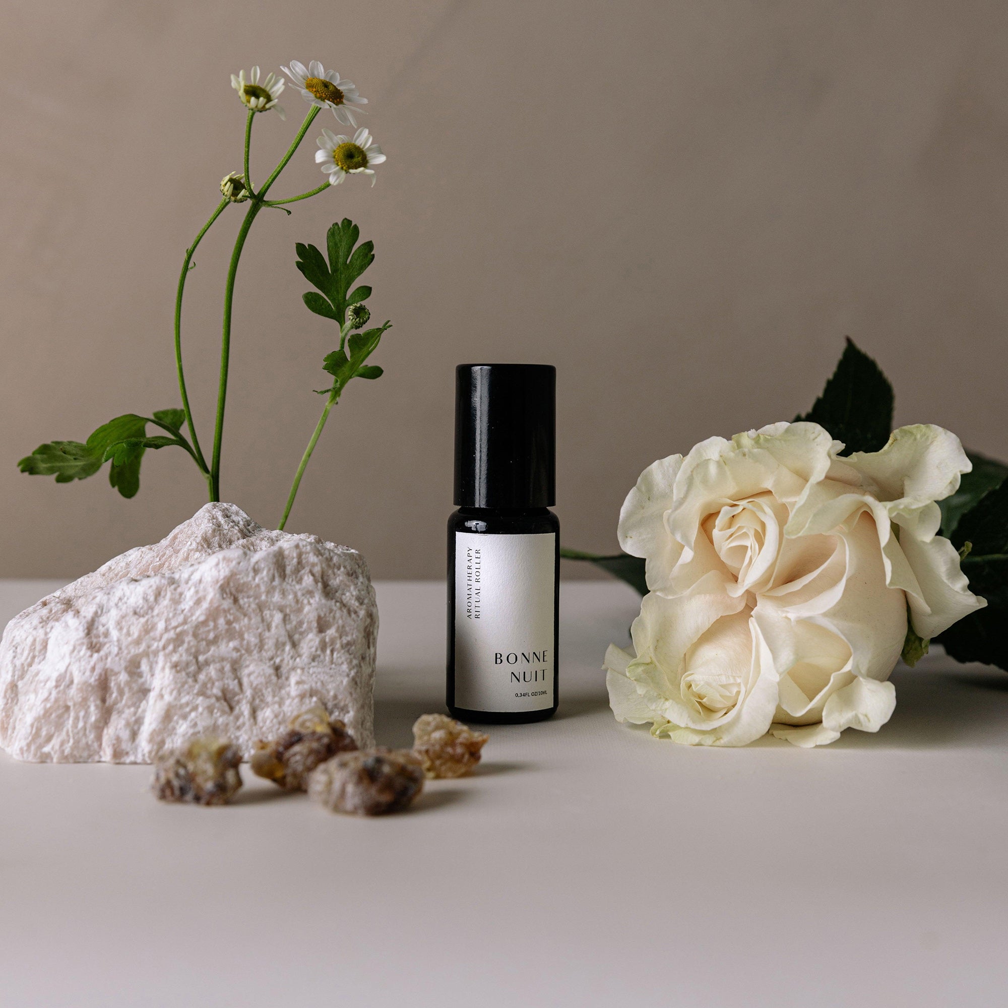 bonne nuit aromatherapy roller with stone, resins, white flower, and stone