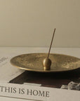 brass sphere incense holder with Japanese incense on the metal plate and book