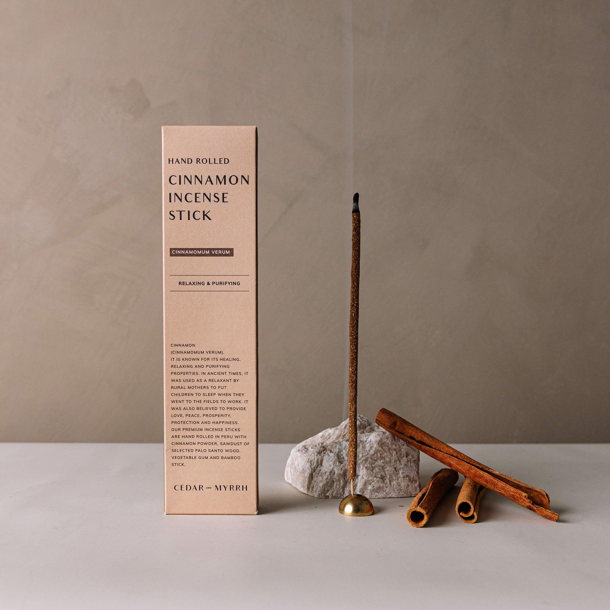 Left: package of cinnamon incense; Right: burning incense stick with incense holder and 3 pieces of cinnamon roll sticks and a rock.