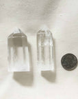 large and medium clear quartz alongside with quarter coin