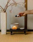 Ethically sourced Palo Santo essential oil being dropped onto an aromatherapy burner, creating a calming and purifying ritual by Cedar and Myrrh