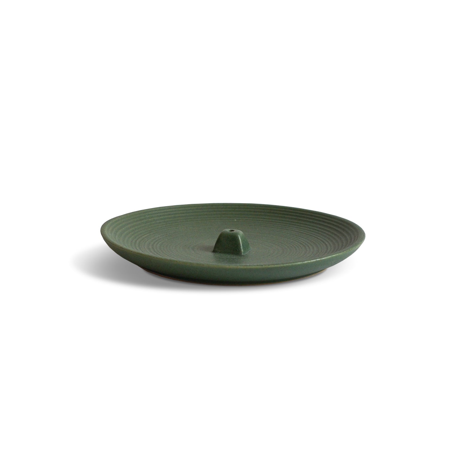 a ceramic wheel-thrown incense holder colored green