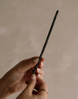 A gif showing the process of burning black copal incense stick.