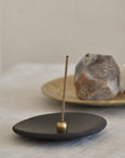 burning an incense from Japan with a brass incense holder and ceramic plate