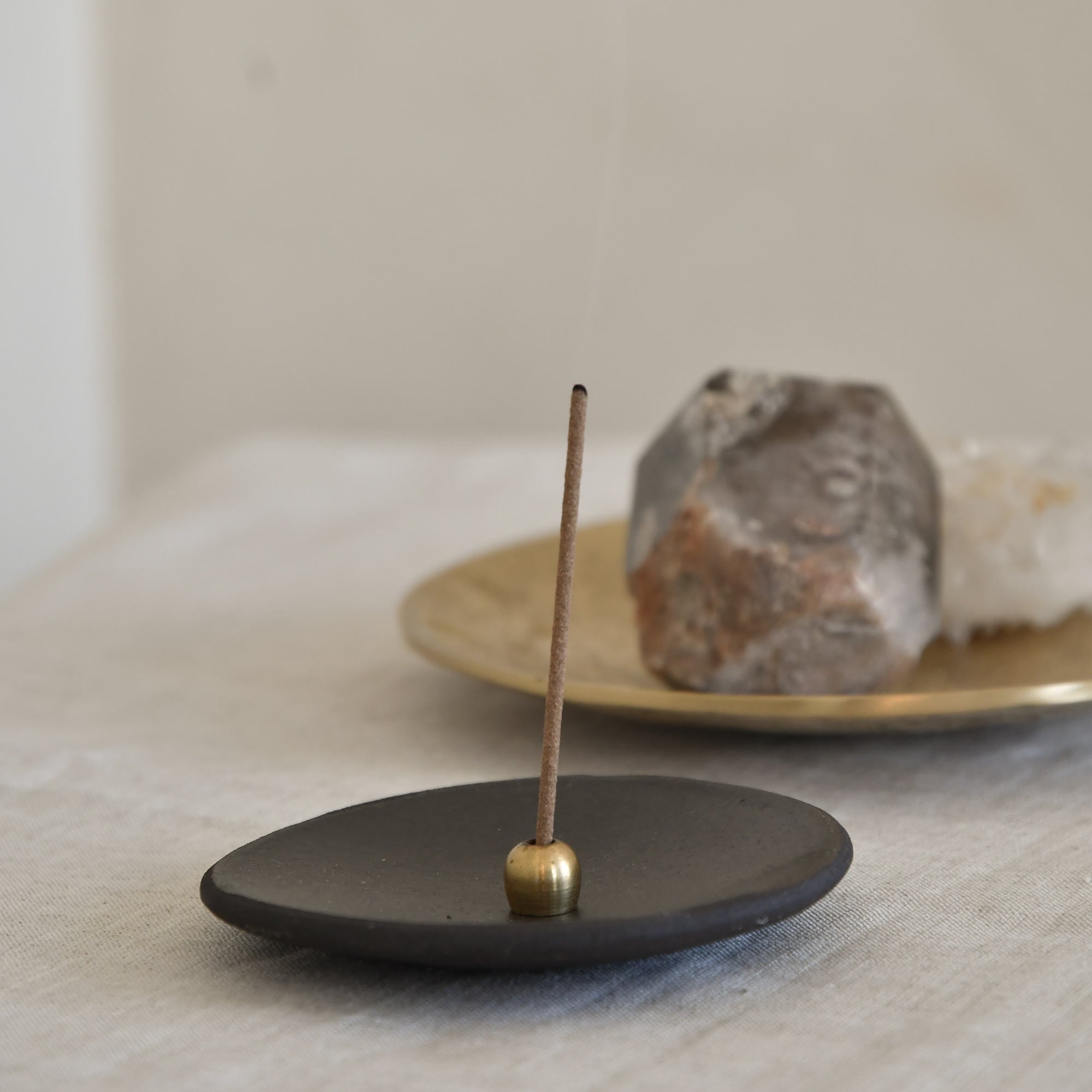 Japanese Incense with an ellipse incense holder and ceramic plate; crystals and metal plate on the behind