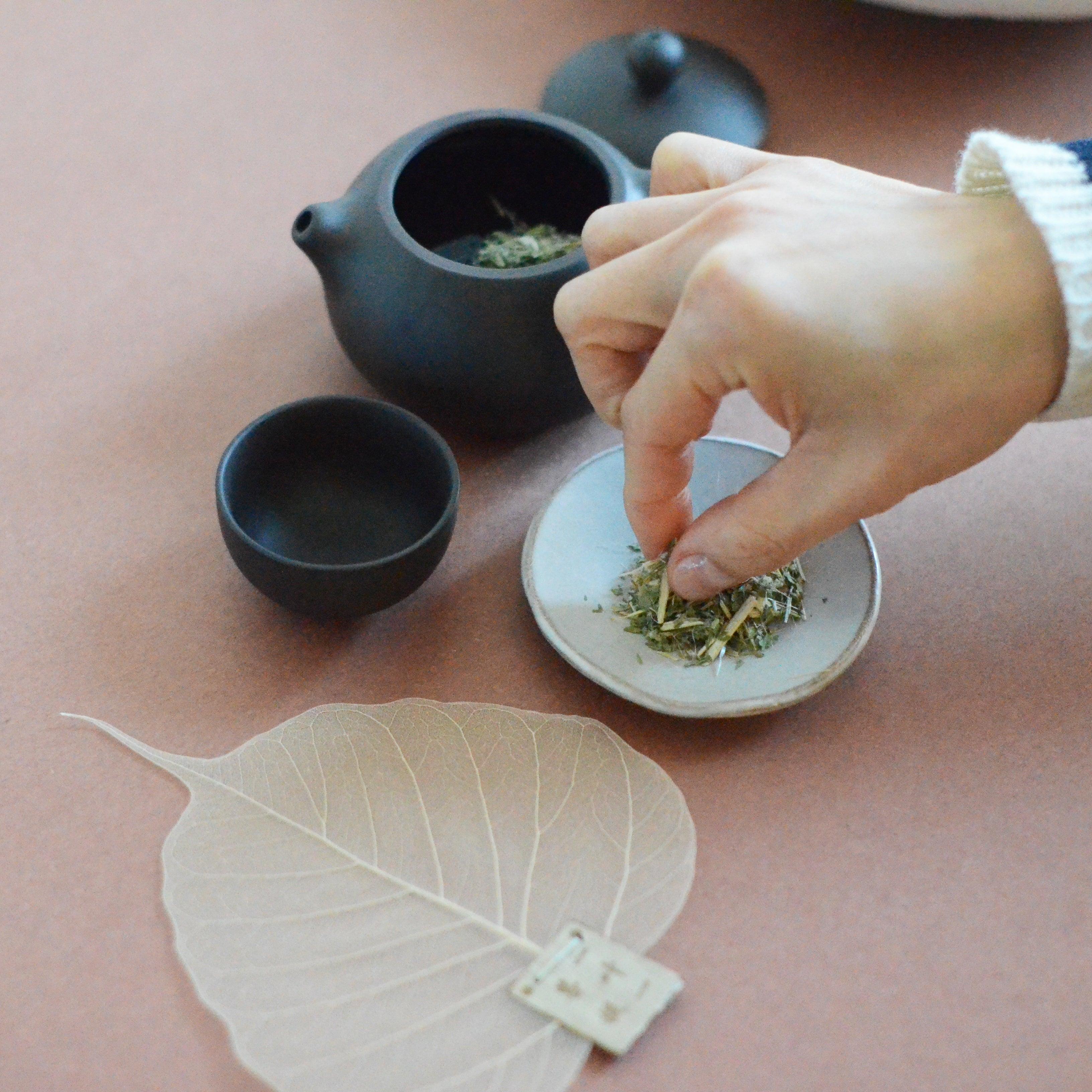 Using a tea strainer to pour the tea on the side while pinching the dried tea leaves