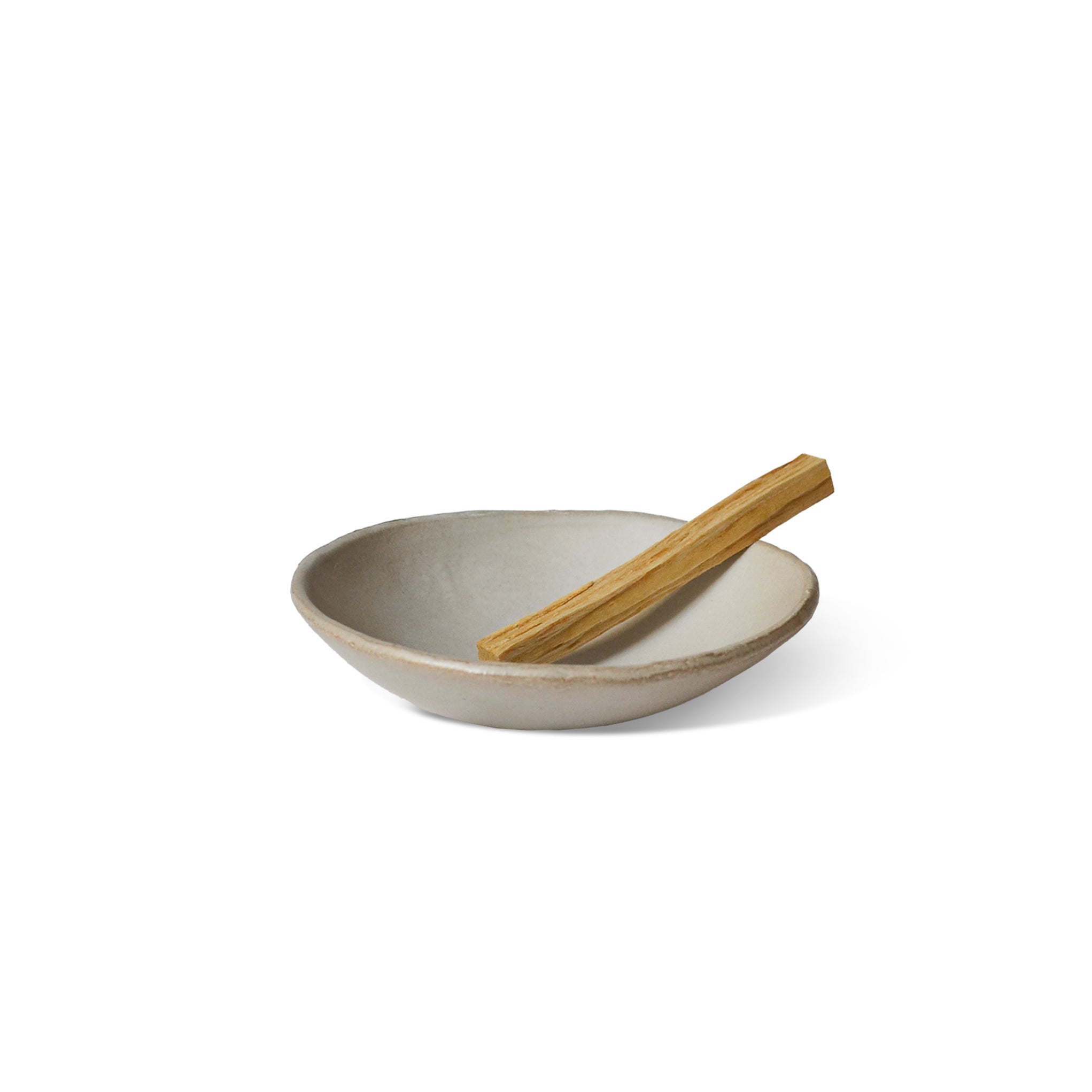 smudge stick on the light grey ceramic incense bowl